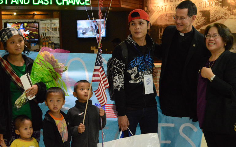 Fr. Lawrence D'Anjou, pastor of St. Raymond Parish in Dublin, Calif, and Tess Chiampas (far right), chair of the parish's refugee resettlement team, stand with Paw Sher Blay (left), her husband, Cha May Htoo, and their three sons after welcoming the family at the Oakland airport, Feb. 25. (Michele Jurich/courtesy of The Catholic Voice, Oakland)