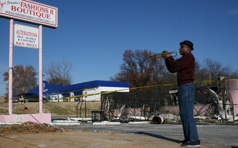 Eugene Gills plays his trumpet in front of the former Juanita's Fashions R Boutique store in Ferguson, Mo., Nov. 28. (CNS/St. Louis Review/Dave Luecking)