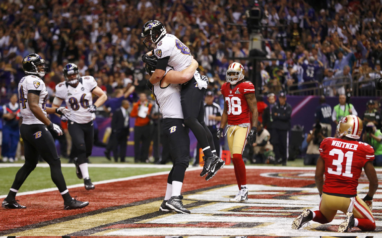 Baltimore Ravens tight end Dennis Pitta is lifted in celebration by teammate Matt Birk after his touchdown against the San Francisco 49ers during the second quarter of the NFL Super Bowl XLVII football game in February in New Orleans. (CNS/Reuters/Jeff Haynes)