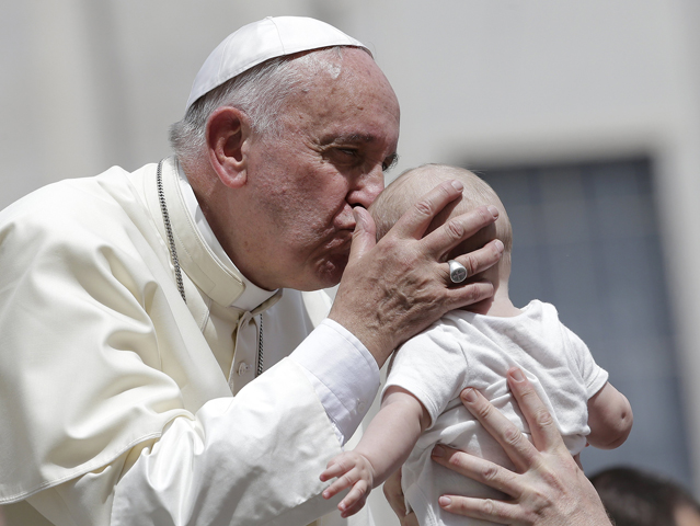 Pope Francis kisses a baby as he leaves his general audience Wednesday in St. Peter's Square at the Vatican. (CNS/Reuters/Max Rossi)