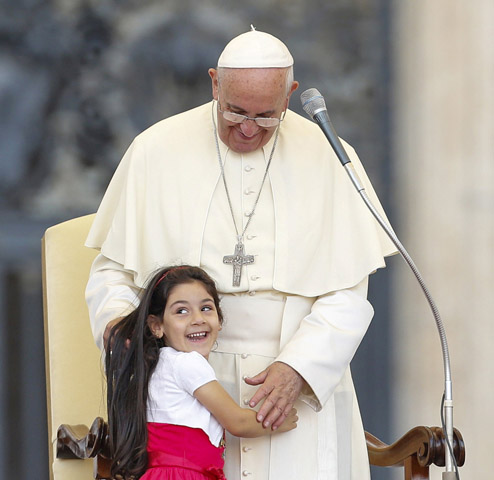 A girl smiles as she embraces Pope Francis during an audience Sunday for families participating in the pastoral conference of the diocese of Rome in St. Peter's Square at the Vatican. (CNS/Reuters/Giampiero Sposito)