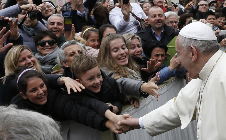 Pope Francis greets people while leaving the general audience Wednesday in St. Peter's Square at the Vatican. (CNS/Paul Haring) 