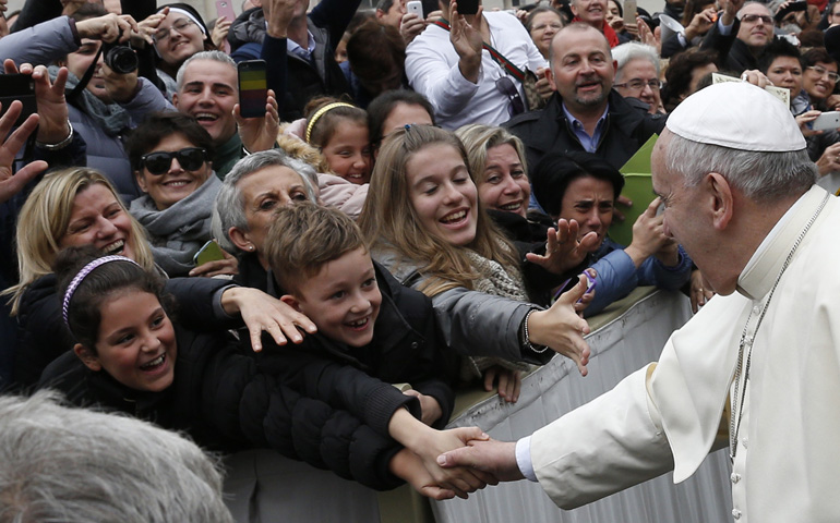 Pope Francis greets people while leaving the general audience Wednesday in St. Peter's Square at the Vatican. (CNS/Paul Haring)