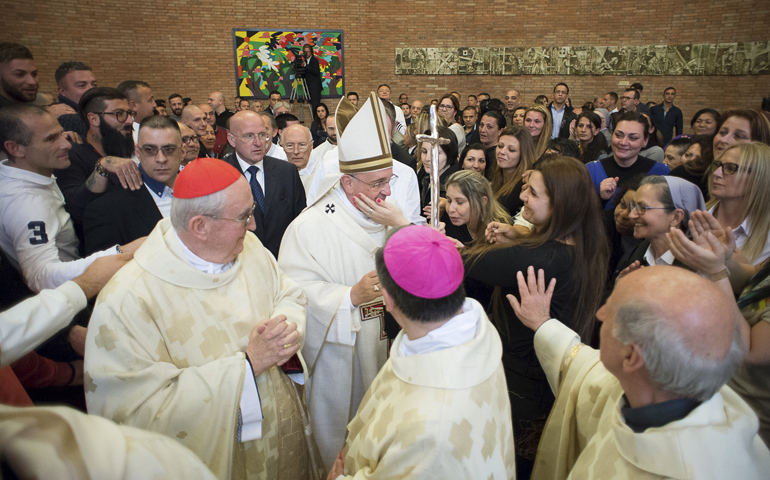 A woman touches Pope Francis' cheek as he meets with inmates and others April 2, Holy Thursday, at Rebibbia prison in Rome. (CNS/Reuters/L'Osservatore Romano)
