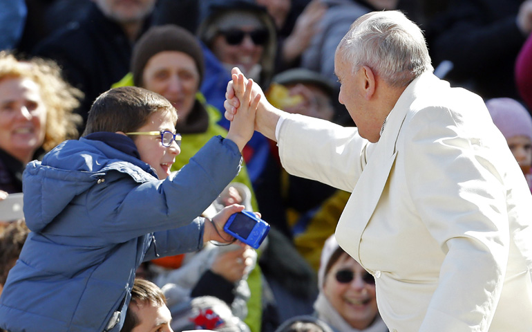 Pope Francis greets a child as he arrives to lead an audience March 7 with the Communion and Liberation movement in St. Peter's Square. (CNS/Reuters/Giampiero Sposito)
