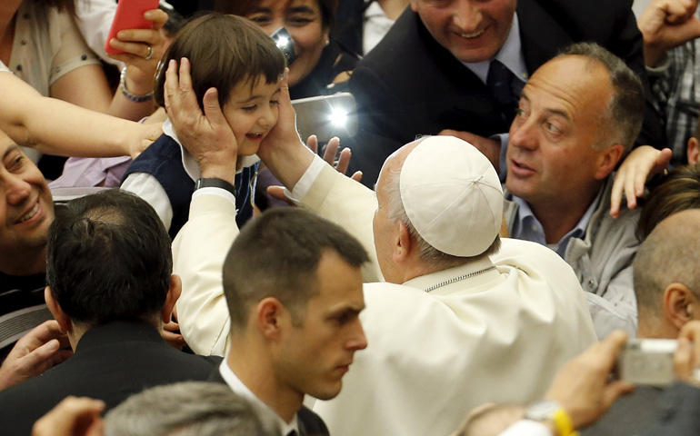 Pope Francis greets a child as he arrives to attend an audience Thursday with members of Christian Life Community in Paul VI hall at the Vatican. (CNS/Reuters/Giampiero Sposito)