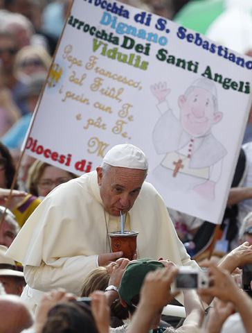 Pope Francis drinks mate, the traditional Argentine herbal tea, as he arrives to lead his general audience Wednesday in St. Peter's Square at the Vatican. The tea was presented by someone in the crowd. (CNS/Paul Haring)