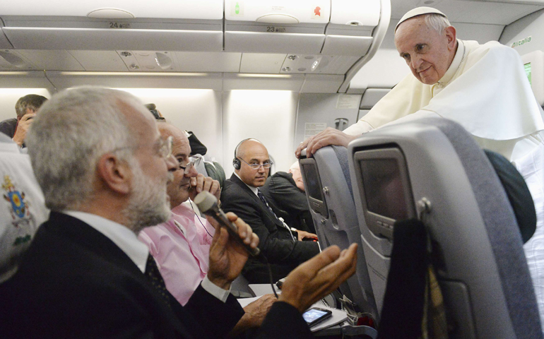 Pope Francis listens to a question from a journalist on his Monday flight back to Rome. The pope answered questions from 21 journalists over a period of 80 minutes on his return from Brazil. (CNS/pool via Reuters)