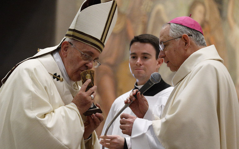 Pope Francis kisses a relic of Blessed Junipero Serra presented by Archbishop Jose Gomez of Los Angeles at the conclusion of Mass celebrated Saturday at the Pontifical North American College in Rome. (CNS/Paul Haring)