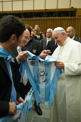 Pope Francis holds a jersey offered to him as a gift after leading a special audience Thursday for the Lazio sport association in Paul VI hall at the Vatican. (CNS/L'Osservatore Romano)