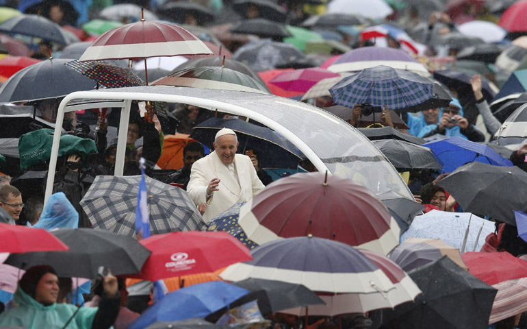 Rain falls as Pope Francis arrives to lead his general audience in St. Peter's Square at the Vatican March 25. (CNS photos)