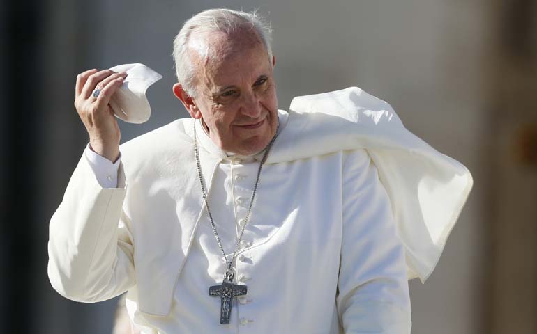 Pope Francis takes off his zucchetto as he leaves his general audience in St. Peter's Square at the Vatican Nov. 6. (CNS/Paul Haring)