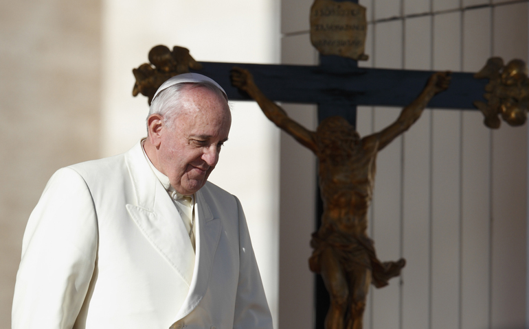 Pope Francis passes a crucifix as he walks down steps during his general audience Dec. 4 in St. Peter's Square at the Vatican. (CNS/Paul Haring)