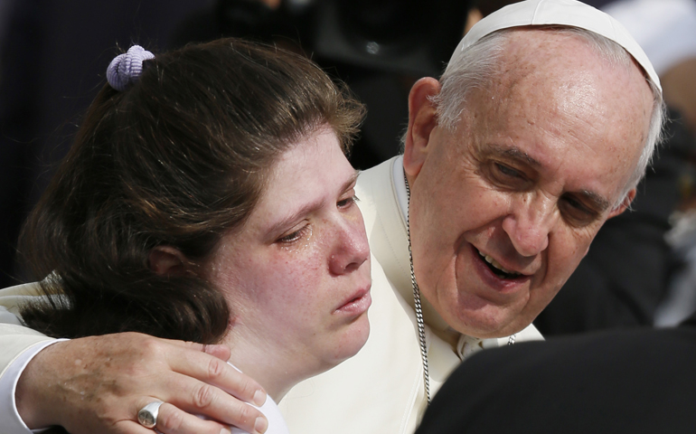 Pope Francis embraces a woman as he greets people with disabilities during his general audience Wednesday in St. Peter's Square at the Vatican. (CNS/Paul Haring)