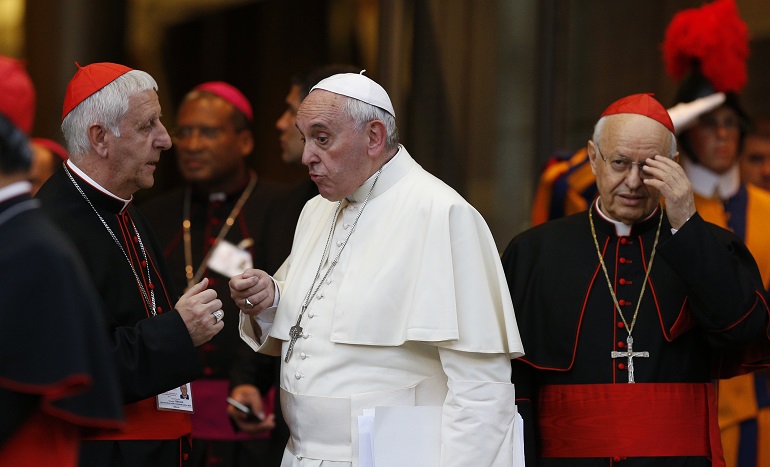 Pope Francis talks with Italian Cardinal Giuseppe Versaldi as they leave the concluding session of the extraordinary Synod of Bishops on the family at the Vatican Oct. 18. At right is Italian Cardinal Lorenzo Baldisseri, general secretary of the Synod of Bishops. (CNS/Paul Haring)