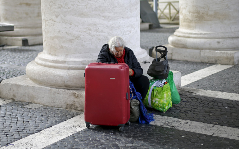 A homeless woman sits with her belongings near the Vatican on March 26. (CNS/Reuters/Max Rossi)