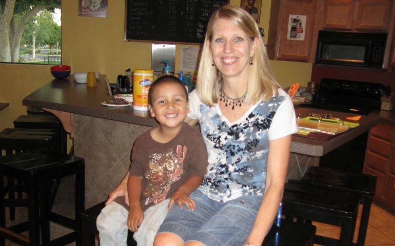Sue Hogenson, a volunteer evening host for Family Promise in Billings, Montana, sits with a young guest who stayed with the program in July 2012. (Courtesy of Family Promise of Yellowstone Valley)