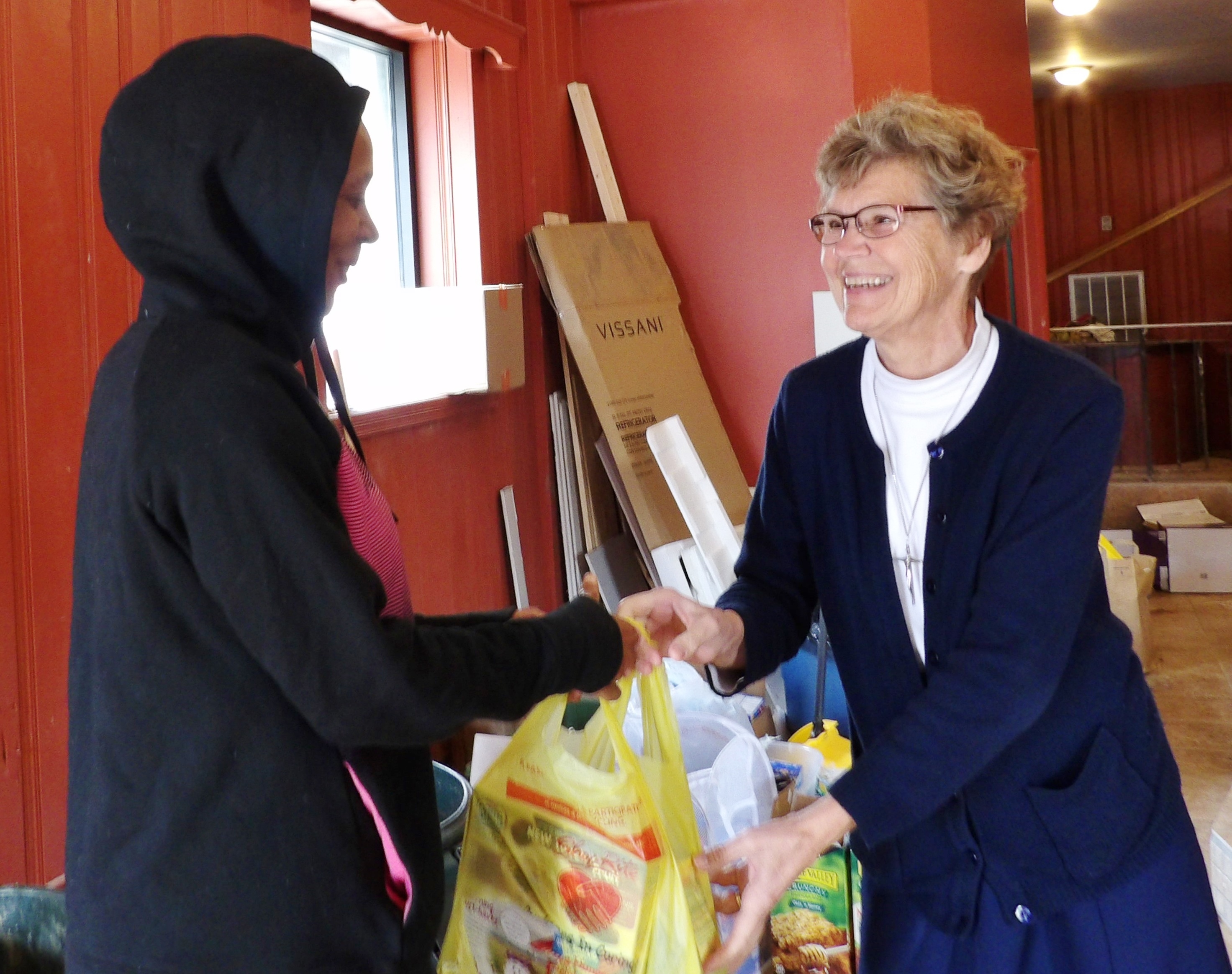 Immaculate Heart of Mary Sr. Ann Raymond Welte, right, distributes food at Mother of Mercy House in Philadelphia in October 2015. (Courtesy of Mother of Mercy House)