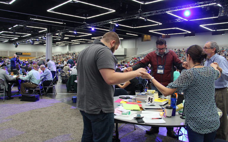 Cutline: Delegates at the 2016 United Methodist General Conference in Portland, Ore., respond in prayer May 18 after hearing from Bishop Bruce Ough. (RNS/Emily McFarlan Miller)
