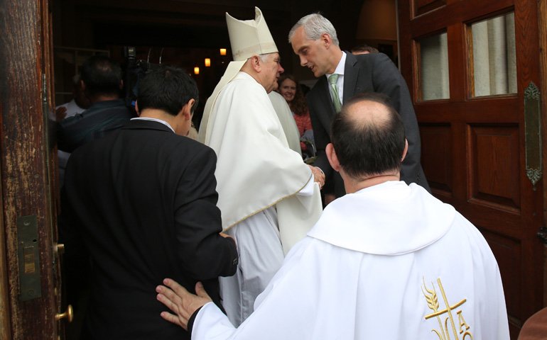 Miami Archbishop Thomas Wenski greets Denis McDonough, White House chief of staff, after celebrating the "Mission for Migrants" Mass on Thursday at St. Peter's Catholic Church on Capitol Hill in Washington. (CNS/Bob Roller)