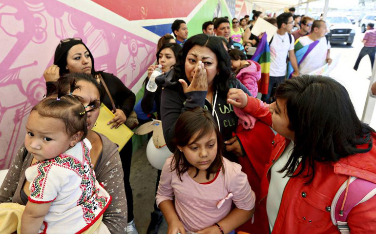 Cecilia Garcia wipes away a tear as she stands in line with deportees during a protest in Tijuana, Mexico, in March 2014. (CNS/Reuters/Sandy Huffaker)