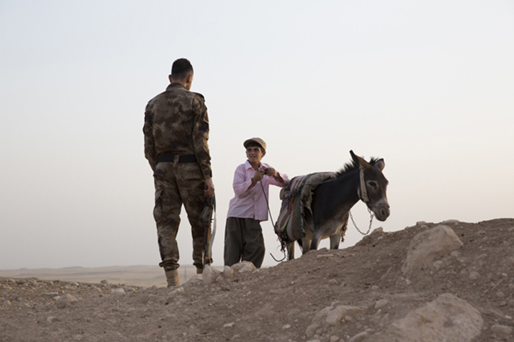 An Assyrian Christian militia member speaks with a shepherd in the town of Alqosh in the Nineveh plains of Iraqi Kurdistan. (Jodi Hilton)