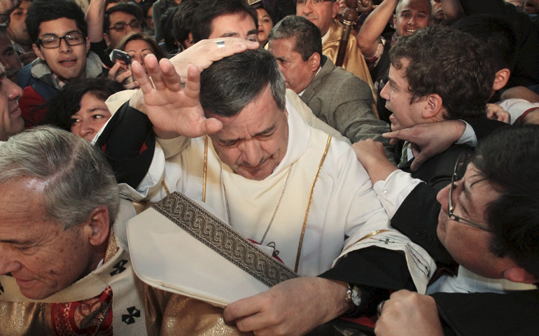 Bishop Juan Barros Madrid, center, attends his first religious service as citizens protest against him March 21 at the cathedral in Osorno, Chile. (Newscom/Reuters/Carlos Gutierrez)