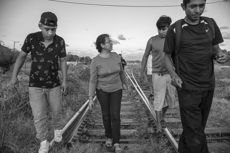 Guardian Angel Sr. Eligia Ayala Molina, center, walks with migrants around the neighboring train tracks. (Lisa Kristine)