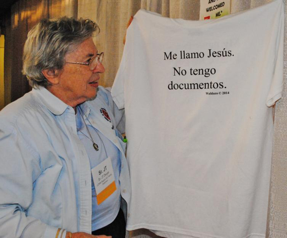 Daughter of Charity Sr. JT Dwyer displays a T-shirt hanging in the LCWR Region XII: Family Detention booth, one of the exhibitors at the assembly. In English on the other side, the shirt says: "My name is Jesus. I have no papers." (GSR photo/Dawn Cherie Araujo)