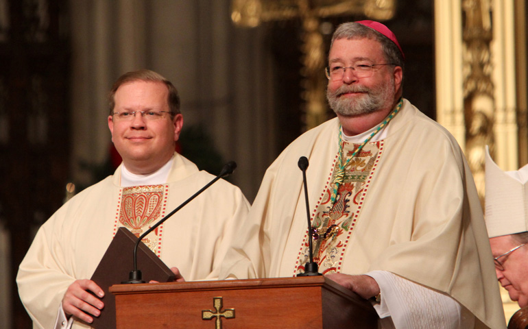 Bishop Daniel R. Jenky of Peoria, Ill., right, smiles as he addresses the assembly during a memorial Mass for Archbishop Fulton J. Sheen at St. Patrick's Cathedral in New York in 2009. Msgr. Stanley Deptula, executive director of the Peoria-based Archbishop Fulton John Sheen Foundation, is at left. (CNS/Gregory A. Shemitz) 