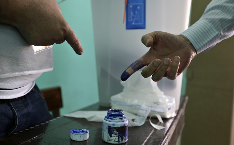 An Iraqi man living in Jordan stains his finger with ink after casting his ballot at a polling station April 27 in a government school in Amman. (CNS/Reuters/Muhammad Hamed, Reuters) 
