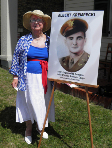 Stella Gumino poses next to a photo of her brother, U.S. Army Pfc. Albert Krempecki, who was killed while trying to help a fellow prisoner in World War II, during a Memorial Day ceremony in South River, N.J. (CNS/The Catholic Spirit/Chris Donahue)