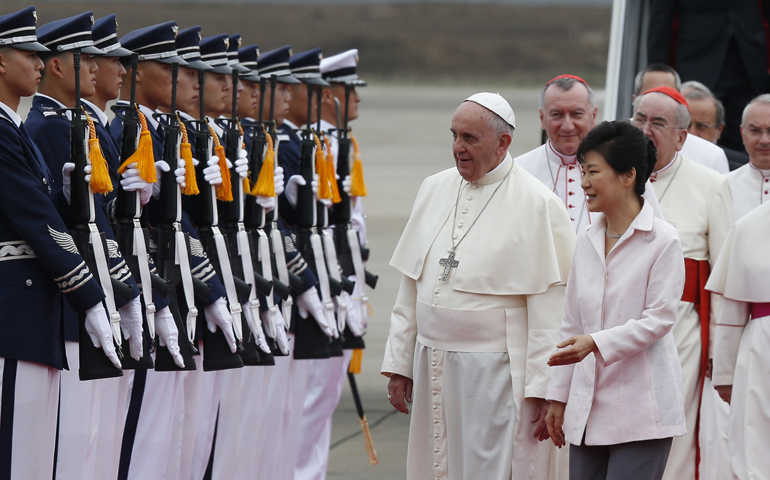 Pope Francis walks with South Korean President Park Geun-hye after landing Thursday in Seoul. (CNS/Paul Haring)