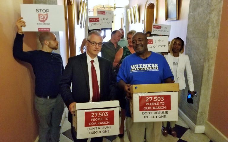 Kwame Ajamu, front right, exonerated Ohio death row survivor, and Carl Ruby, front left, senior pastor of Central Christian Church, help deliver petitions from thousands of Ohioans and citizens across the country to Gov. John Kasich asking him to halt executions on July 19. (Ohioans to Stop Executions)