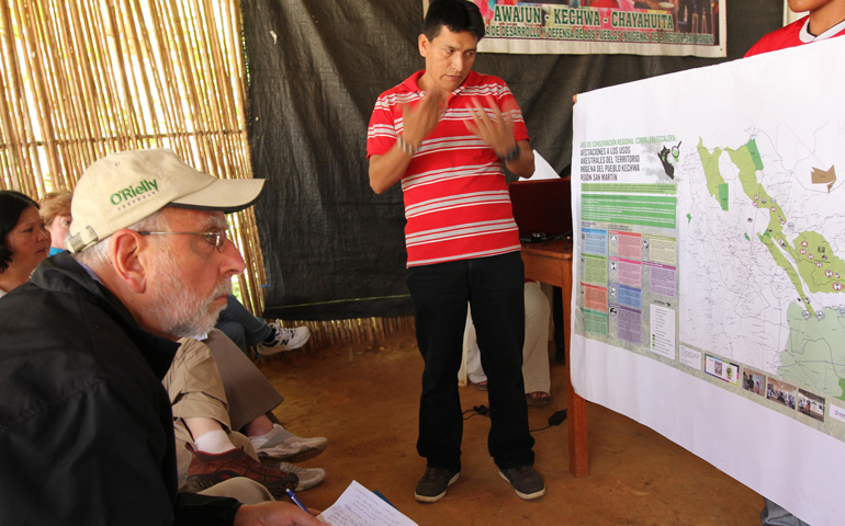 Bishop Gerald Kicanas of Tucson, Ariz., chairman of the board of Catholic Relief Services, listens to Kechwa leader Walter Sangama explain communities' land-rights conflicts in Lamas, Peru, June 27. (CNS/Barbara Fraser) 