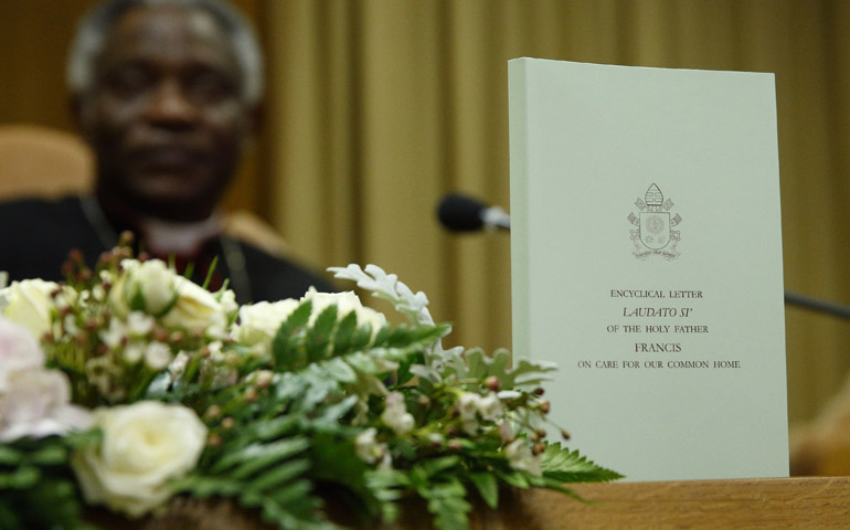 The English edition of Pope Francis' encyclical on the environment at a news conference June 18 at the Vatican. At left is Cardinal Peter Turkson, president of the Pontifical Council for Justice and Peace. (CNS/Paul Haring) 
