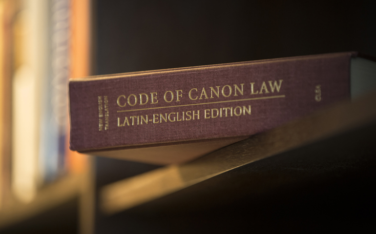 A Latin-English edition of the Code of Canon Law is pictured on a bookshelf. (CNS) 