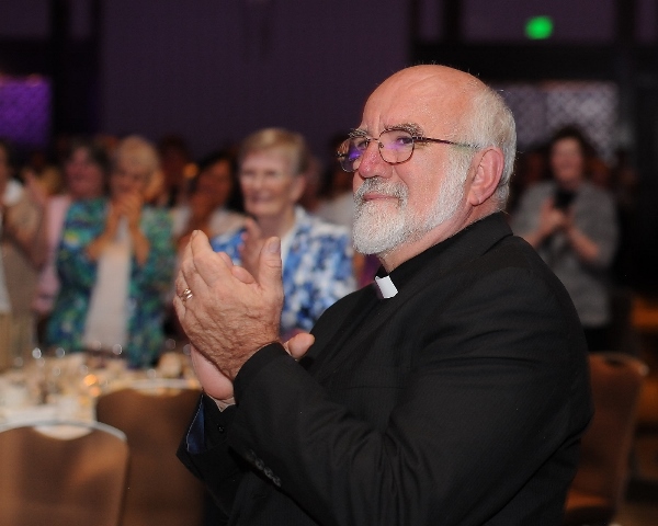 Fr. Hank Lemoncelli claps for Sr. Janet Mock during the banquet and award presentation of the Assembly of the Leadership Conference of Women Religious at the Hyatt Regency Hotel in Houston, Texas, Aug. 14, 2015. (NCR photo / Dave Rossman)