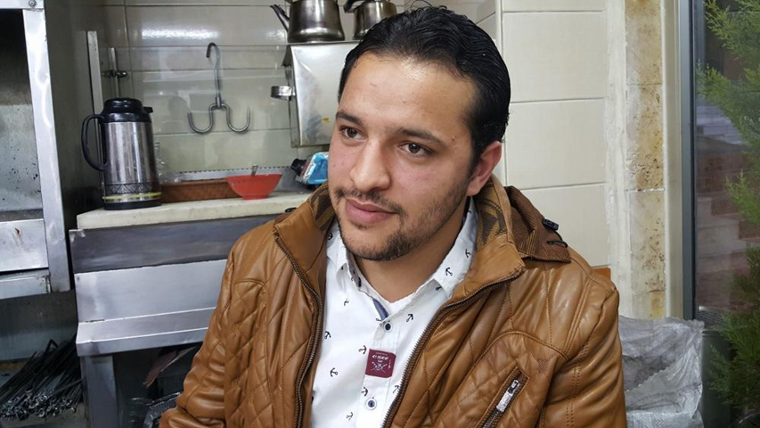 Mohammad Rostom, 23, in the small restaurant in Amman, Jordan, where some of his relatives work. They are all originally from Syria. (GSR/Chris Herlinger)