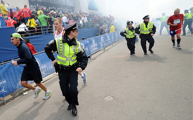 Police and runners react following two explosions Monday at the Boston Marathon finish area. (CNS/MetroWest Daily News/Ken McGagh, handout via Reuters) 