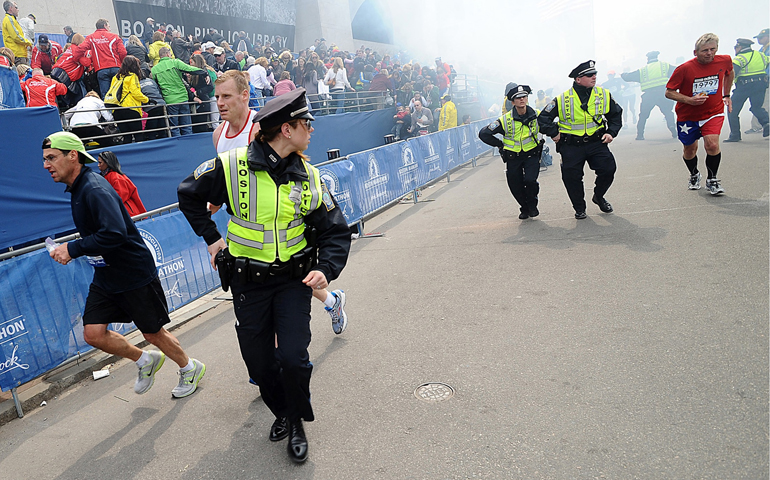 Police and runners react following two explosions Monday at the Boston Marathon finish area. (CNS/MetroWest Daily News/Ken McGagh, handout via Reuters)
