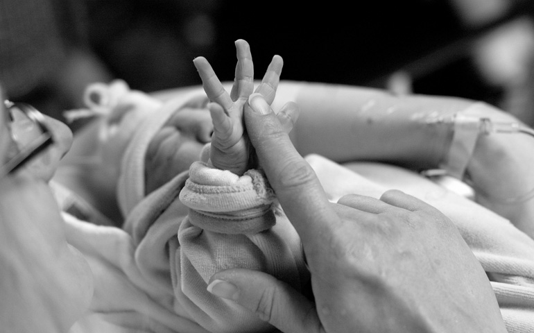 Chantell Reagan touches the hand of her newborn son, Gabriel John, after his birth in 2007. (CNS/Courtesy Now I Lay me Down to Sleep)
