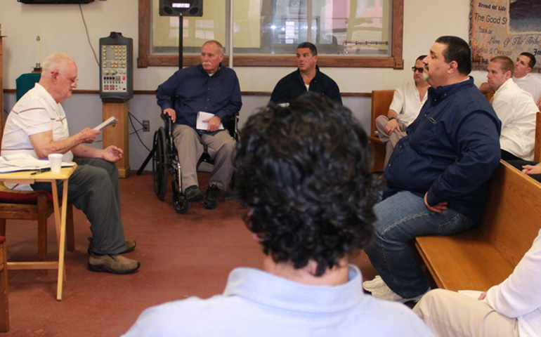 John Collins, left, shares part of a column he wrote for The Catholic Free Press newspaper with prisoners at the Massachusetts Correctional Institution in Shirley, Mass. (CNS/The Catholic Free Press/Tanya Connor)