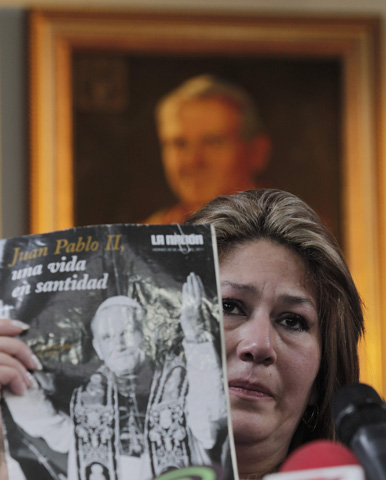 Floribeth Mora Diaz, the Costa Rican woman whose inexplicable cure has been attributed to the intercession of Blessed John Paul II, displays a magazine cover as she gives her testimony to the media Friday in San Jose, Costa Rica. (CNS/Reuters/Juan Carlos Ulate)