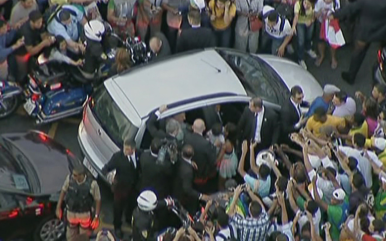 People mob the car carrying Pope Francis as it gets stuck in traffic Monday as the pope is driven from the airport to the Metropolitan Cathedral in Rio de Janeiro in this still image taken from video. (CNS/video pool via Reuters)