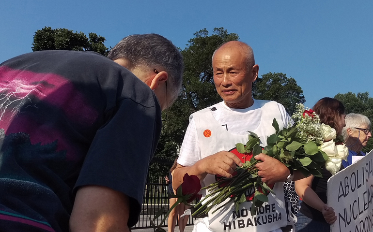 Hiroshima survivor Toshiyuki Mimaki receives roses from a peace activist in front of the White House in Washington Aug. 6, the 71st anniversary of the U.S. dropping an atomic bomb on Hiroshima, Japan. (CNS/James Martone)
