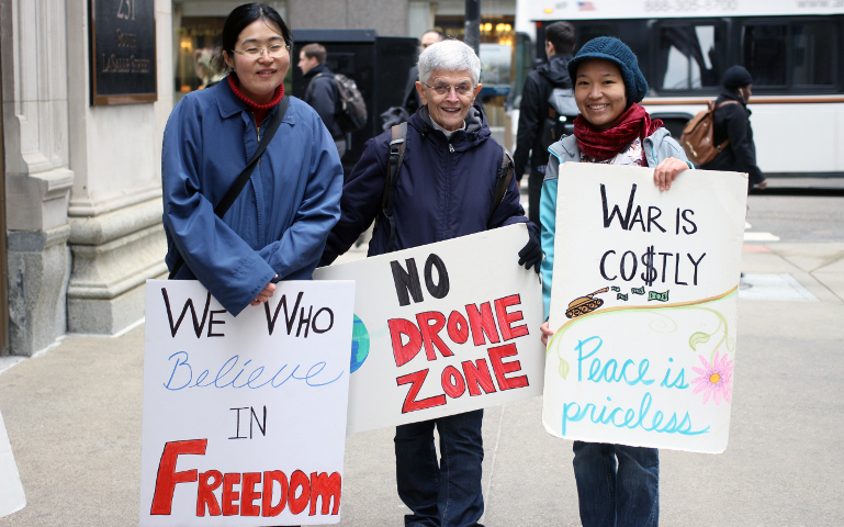 Sr. Kathleen Desautels, center, with 8th Day Center intern Elsa Loekito, right, and a friend of Loekito's at a peace vigil in 2017 (Courtesy photo)