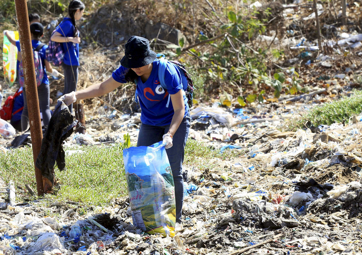A volunteer picks up trash at Freedom Island, a marshland considered to be a sanctuary for birds, fish and mangroves in April in the Philippines. (CNS/Reuters/Romeo Ranoco)