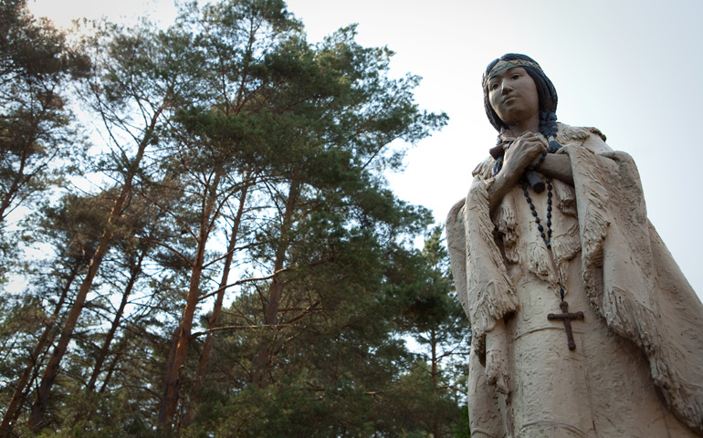 A statue of St. Kateri Tekakwitha stands amid trees on the grounds of the shrine dedicated to her in Fonda, N.Y. The 17th-century Mohawk-Algonquin woman is the first member of a North American tribe to be declared a saint. (CNS/Nancy Phelan Wiechec) 