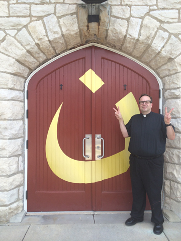Fr. Jim Sichko, pastor of St. Mark Catholic Church in Richmond, Ky., stands outside the church's doors, which Sichko had painted with an Arabic letter "Nun" July 31, in solidarity with persecuted Iraqi Christians. Islamic State militants in Mosul have marked Christian homes with the letter to stand for Nazarene, or Chrisian. (Courtesy of Fr. Jim Sichko)